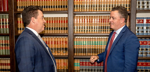 Jonathan and James Tyack talk in the law library