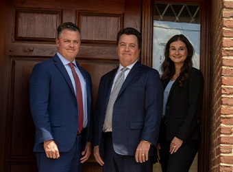 Tyack Law Lawyers pose outside their office door
